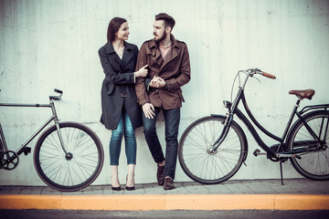 Young couple with a bicycle opposite city 