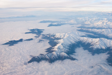 Fototapeta premium Above the clouds aerial view of snowcapped andes mountains