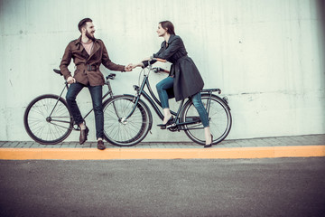 Young couple with a bicycle opposite city 