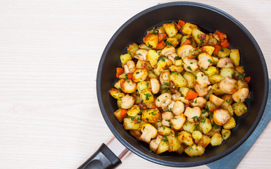 Fried potato with mushrooms in a frying pan