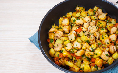 Fried potato with mushrooms in a frying pan