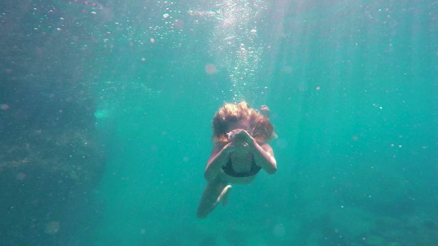 Woman Swimming Underwater In Slow Motion. Swimming Towards Camera by Coral Reef in Ocean in Hawaii. Young Attractive Beautiful Woman Mermaid.