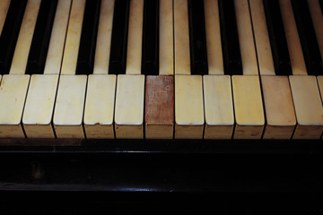 Fototapeta na wymiar piano keys and wood grain with vintage sepia tone one ragged key