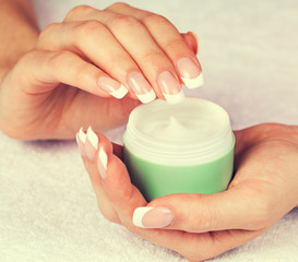 jar with cream in female hands