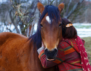 portrait woman and horse cuddling outdoors. 