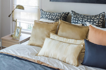 pillows on luxury bed with white lamp in bedroom