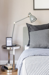 modern grey lamp with alarm clock on side table in bedroom