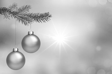 Silberne Weihnachtskugeln vor silbernem Hintergrund