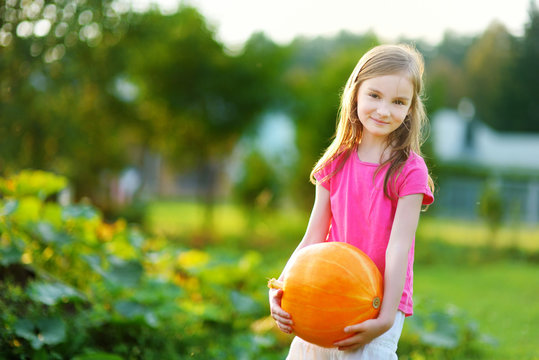Cute little girl holding a pumpkin