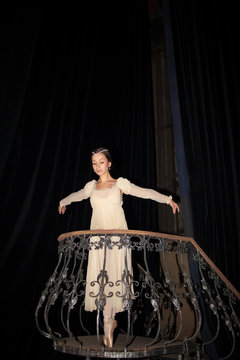 The beautiful ballerina posing in long white dress