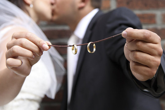 Pan młody i panna młoda trzymają obrączki