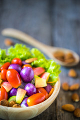 Fresh vegetable salad on wooden background.
