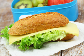 Brown roll with cheese and lettuce, closeup
