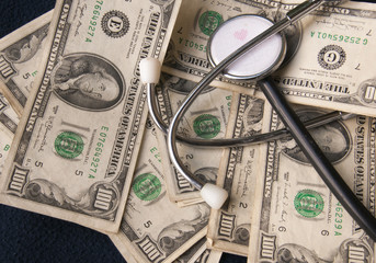 The health costs: a stetoscopio supported on the dollars