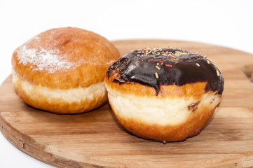 Donuts with chocolate and vanilla on the wooden board