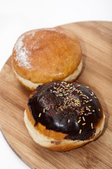 Donuts with chocolate and vanilla on the wooden board