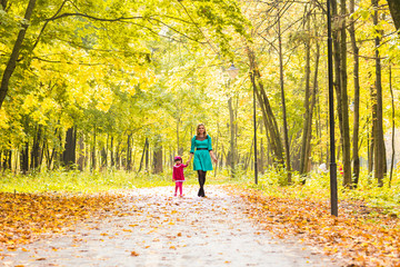 Fototapeta premium happy mother with her daughter for a walk in autumn park