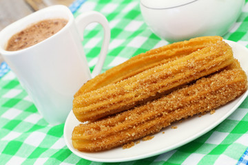 Spanish churros on plate and cup of hot chocolate
