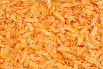 Grated carrots background.Top view of mandoline cut carrots.
