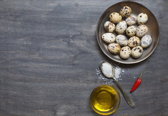 Plate with quail eggs, salt, olive oil and pepper
