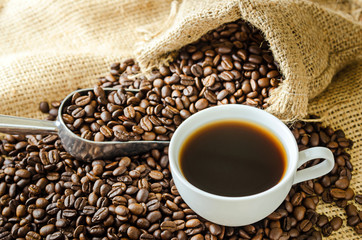 white coffee cup and coffee beans around