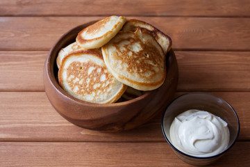 Fried fritters on plate with sour cream