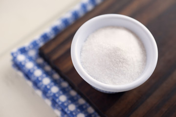Salt. High angle view of white bowl full of salt. Very shallow depth of field.