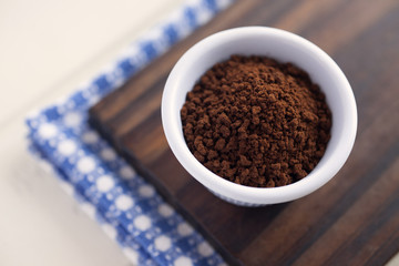 Instant coffee. High angle view of white bowl full of instant coffee. Very shallow depth of field.