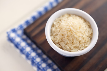 Parboiled rice. High angle view of bowl containing parboiled rice. Very shallow depth of field.