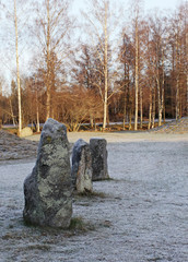 The big stones standing in the snow field in winter
