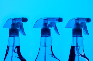 Three Spray Bottles With Blue Light
