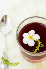 Obraz na płótnie Canvas Red wine jelly with white flowers and ice