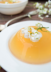 orange jelly with white flowers on wooden background