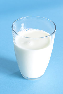 Glass of fresh milk on a blue background