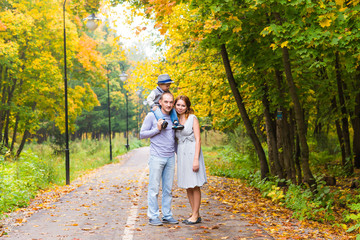 Fototapeta premium Young family for a walk in the autumn park with baby