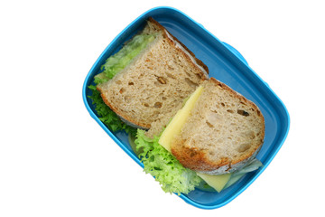 Lunch box containing rustic bread sandwiches with cheese and lettuce isolated on white
