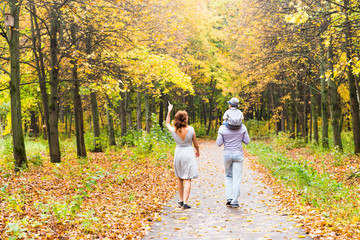 Young family for a walk in the autumn park with baby