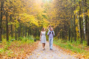 Young family for a walk in the autumn park with baby