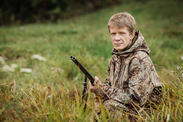 hunter in camouflage clothes ready to hunt with hunting rifle