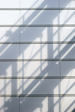 Blechverkleidung mit Schatten / Ein abstrakter Schatten eines Gel&auml;nder  auf einer Blechverkleidung