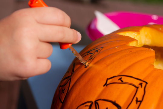 Kinderhand beim K&uuml;rbis schnitzen f&uuml;r Haloween - Nahaufnahme