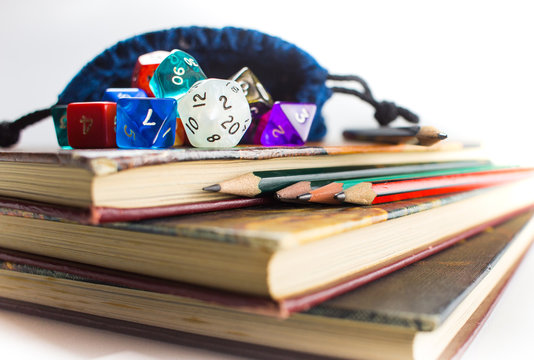 Close up of Dice and Pencils on top of Books