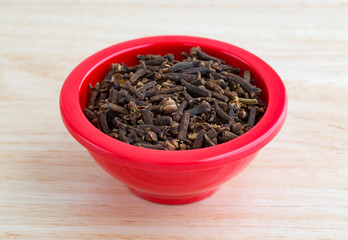 Whole cloves in a red dish on counter