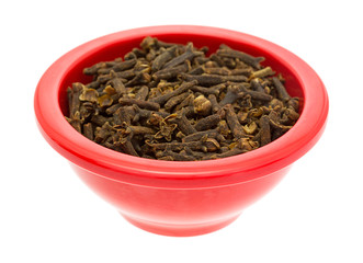 Red dish filled with whole cloves on white background