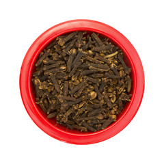 Red dish with whole cloves on a white background