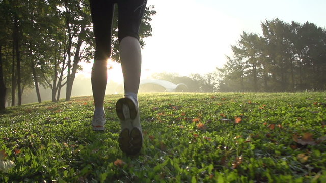 Young fitness woman having an exercise run in a park, slow