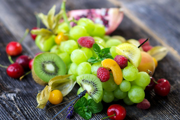 Delicious mixed fresh fruits on wooden background