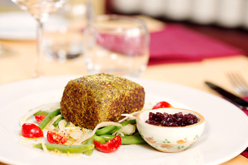 tuna with pistachio crust and vegetables with restaurant table
