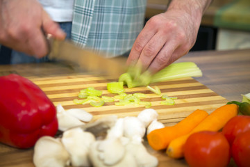 Obraz na płótnie Canvas Food preparation - Chopping celery in blurred motion.