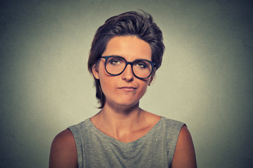 Skeptic. Doubtful woman in glasses looking at you - obrazy, fototapety, plakaty